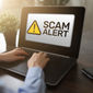 Scam alert displayed on a laptop computer.
