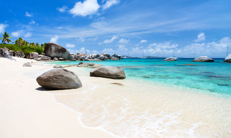Beautiful tropical beach with white sand, turquoise ocean water and blue sky at Virgin Gorda, British Virgin Islands in Caribbean (Photo via shalamov / iStock / Getty Images Plus)