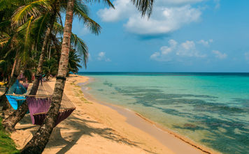 tropical beach with hammock on palm, relax concept from Nicaragua (Photo via riderfoot / iStock / Getty Images Plus)