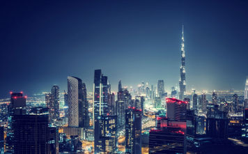 Beautiful Dubai cityscape, bird's eye view on a night urban scene, modern city panoramic landscape, United Arab Emirates (photo via Anna_Om / iStock / Getty Images Plus)