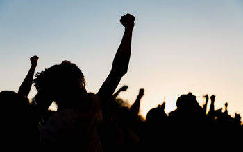 People holding fists up at a protest.