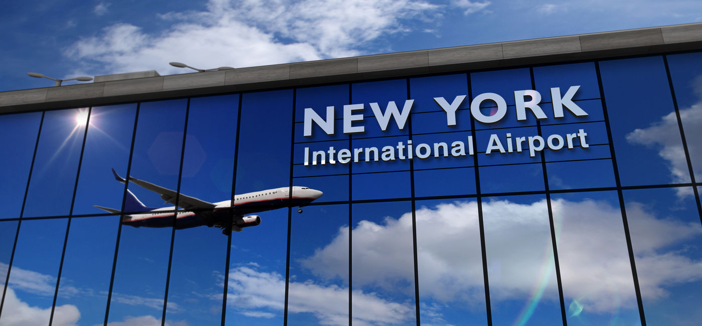 Image: Reflection of airplane landing at New York's JFK International Airport. (Photo Credit: Adobe Stock/Skórzewiak)