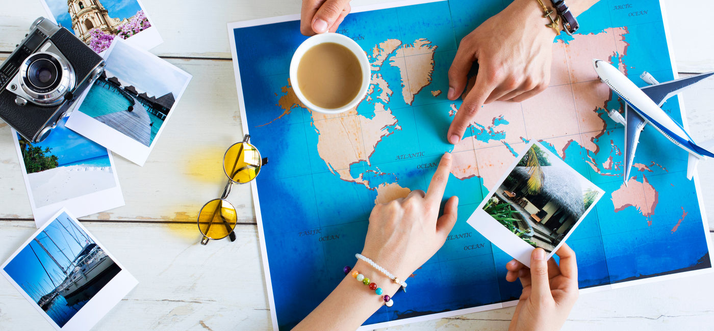 Image: Travel advisor helping plan a trip. (Photo Credit: sebra/Adobe Stock)