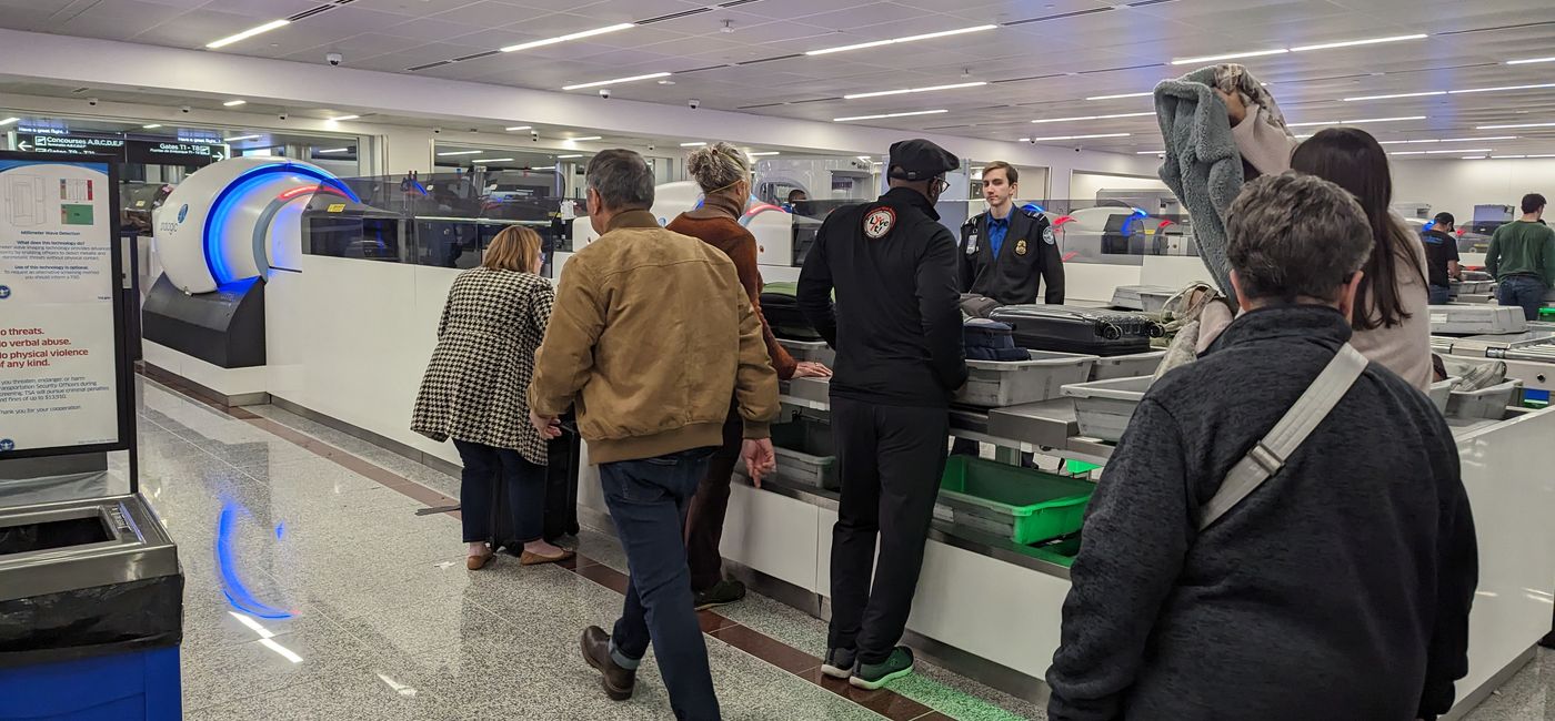Image: Travelers placing items in bins at TSA security line. (photo by Eric Bowman)